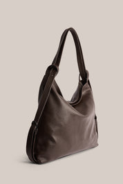 Brown leather handbag on a beige background