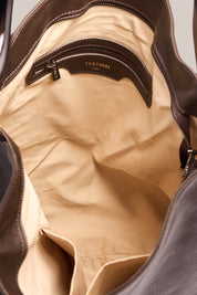 Close-up of a beige leather bag with a visible brand logo.